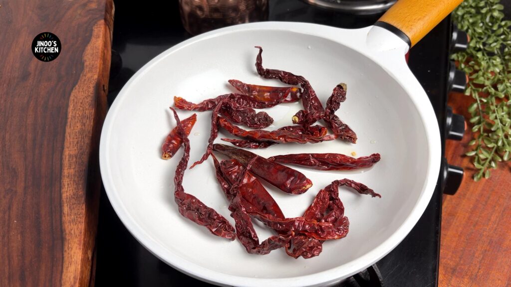 Regular and Kashmiri red chillies roasting in a pan for brinjal chutney