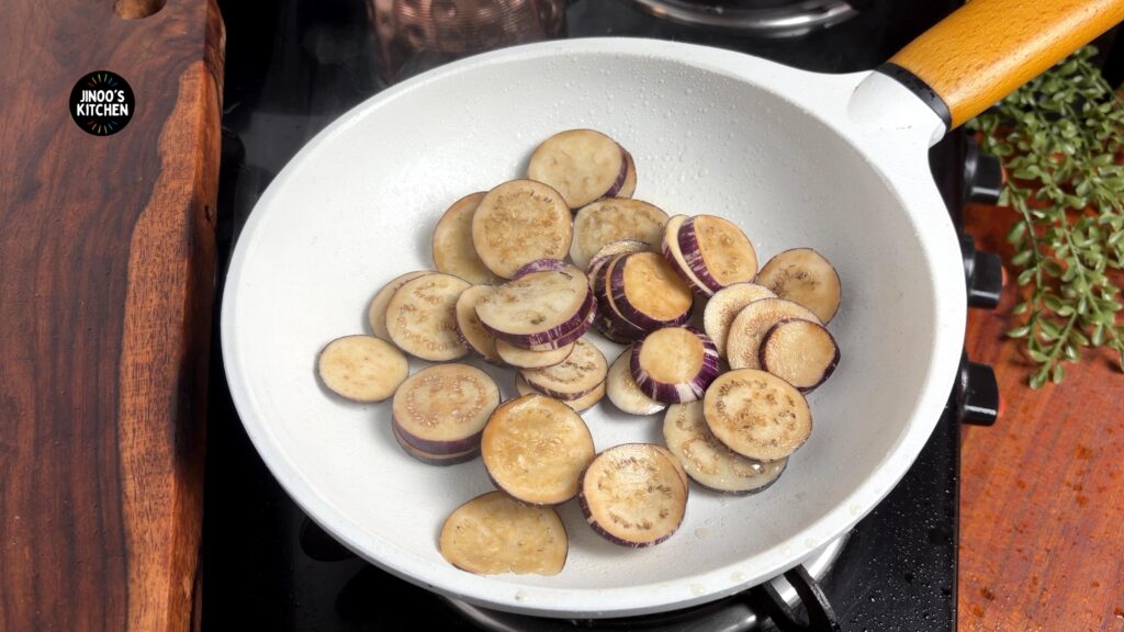 adding the brinjal to the pan with salt
