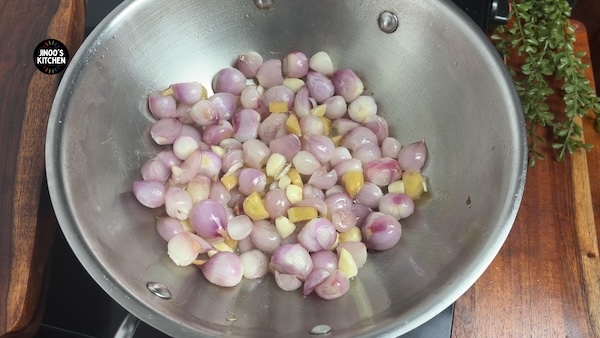 Small onions, ginger and garlic frying in sesame oil for Kongu chicken curry until soft