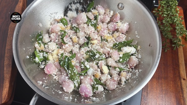 Grated coconut frying with onions and curry leaves for chicken masala